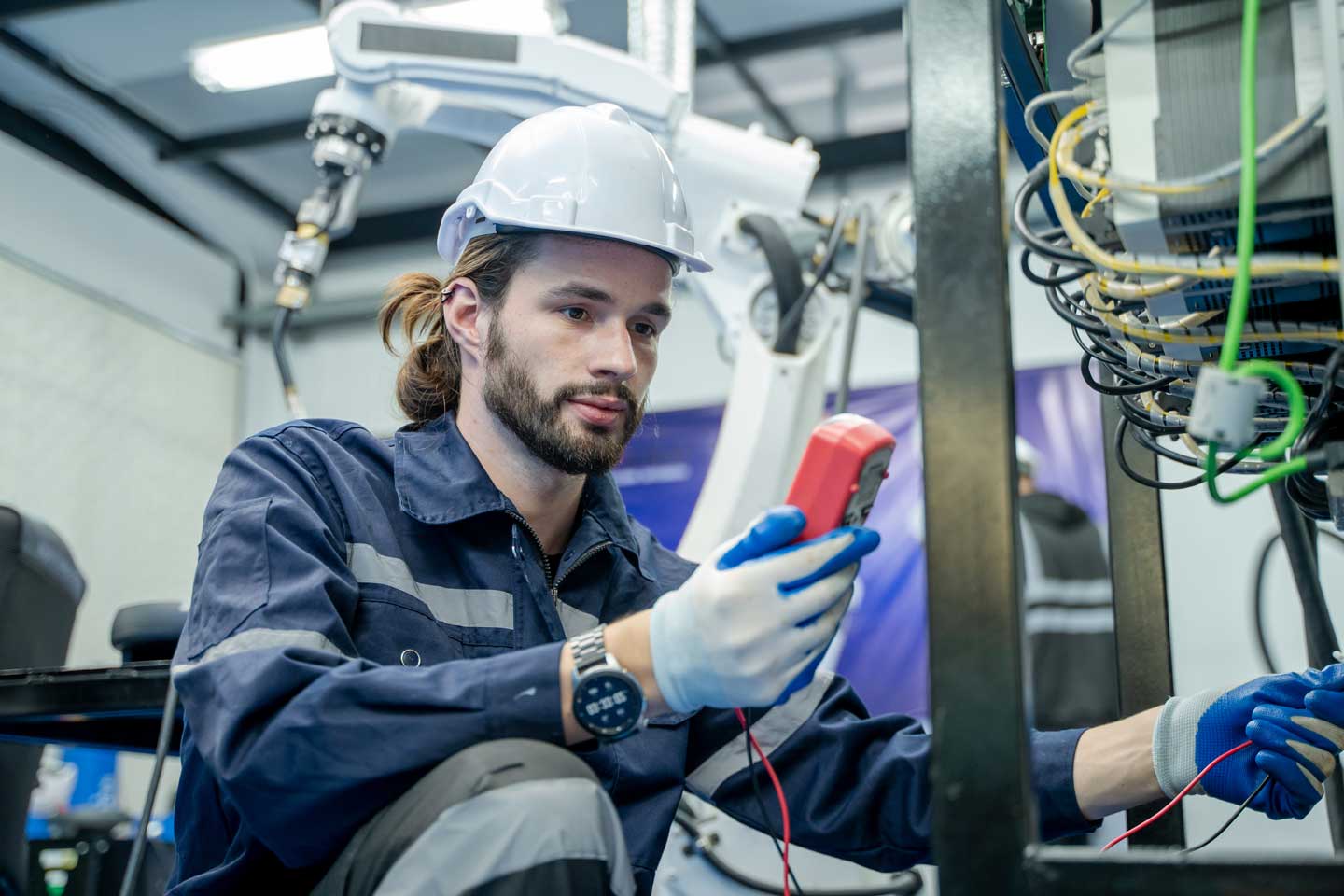 A Spartan Electric electrician testing a live circuit with a multimeter